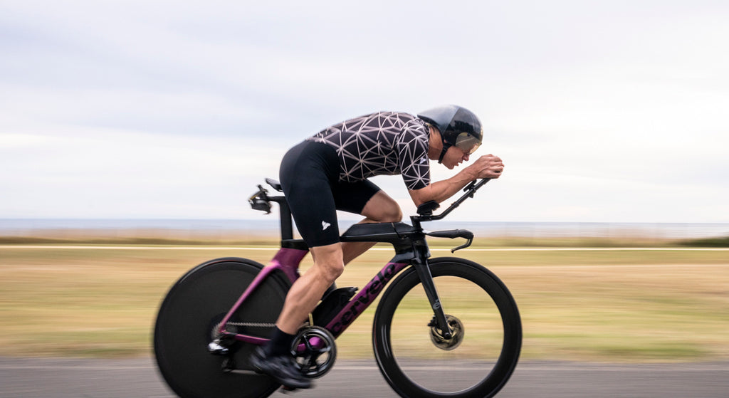 Man cycling along the rocks in the EVO black mens tri suit