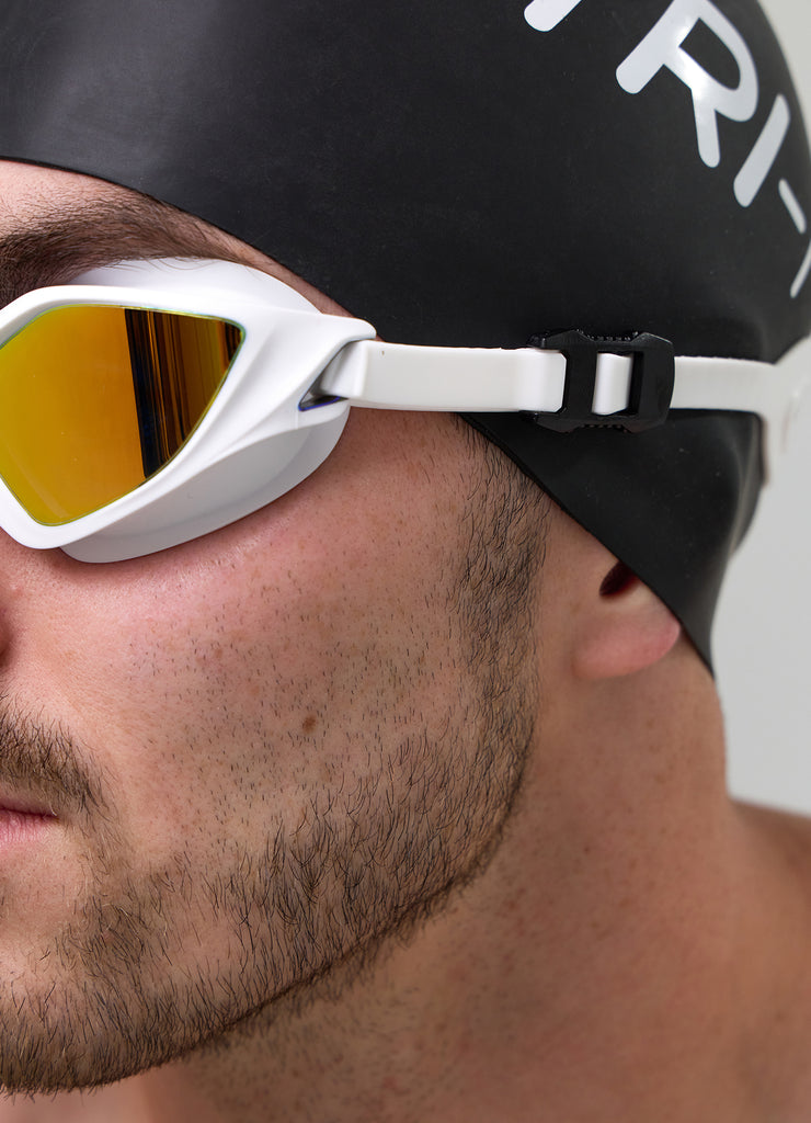 Male swimmer wearing TRI-FIT RAPID-X swim goggles in white