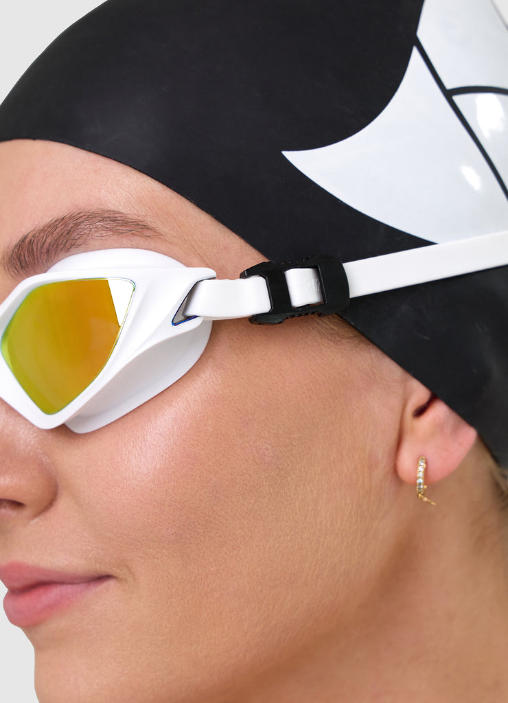 Female swimmer wearing TRI-FIT RAPID-X swim goggles in white