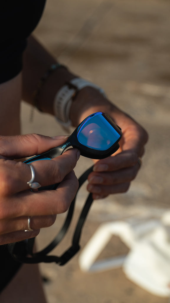 Women wearing TRI-FIT PROPEL Reversible Swimsuit with PROPEL Goggles  in her hands.